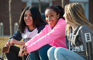 three girls sitting on curb