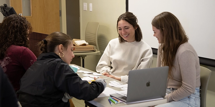 four female students working on a group project at a desk